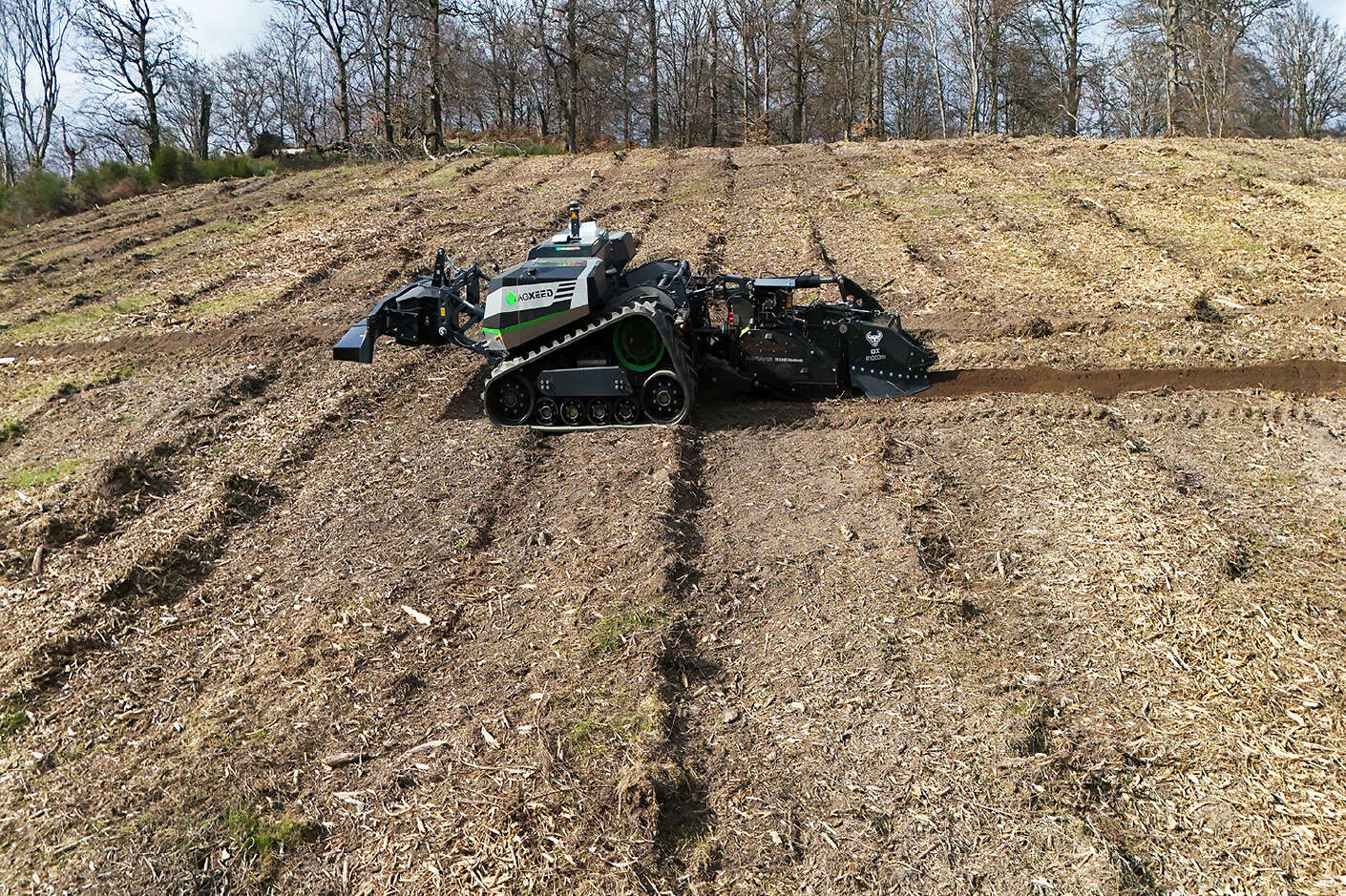 Autonomer AgXeed-Roboter beim Bodenmanagement im Forst mit Raupenlaufwerk und Anbaufräse im Einsatz.