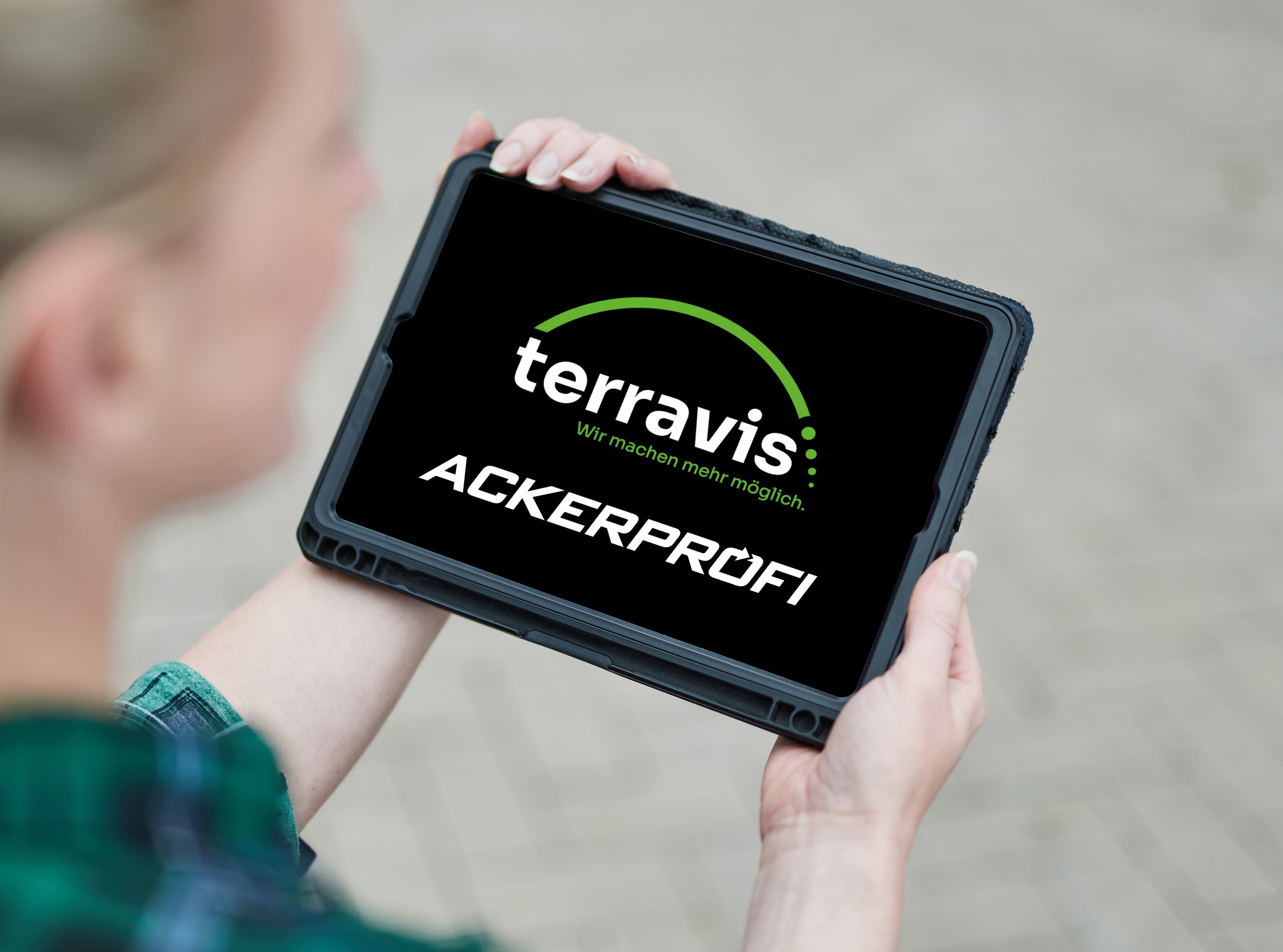 Eine Frau hält ein Tablet. Auf dem Tablet ist das TerraVis und das Ackerprofi Logo zu sehen.