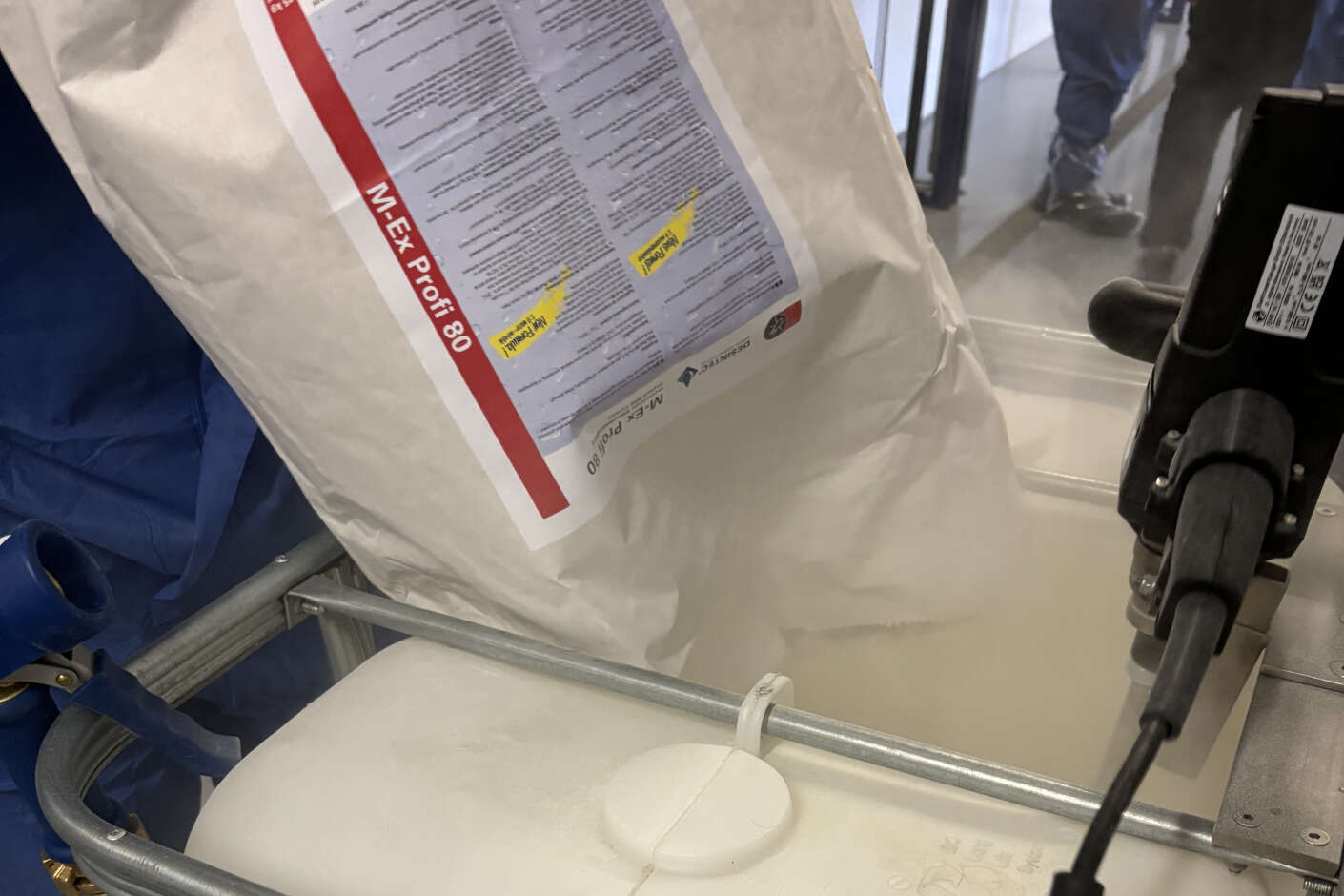 Ein Pulver wird in einen Container gekippt und zu einem Mittel gegen Milbenbekämpfung angerührt.