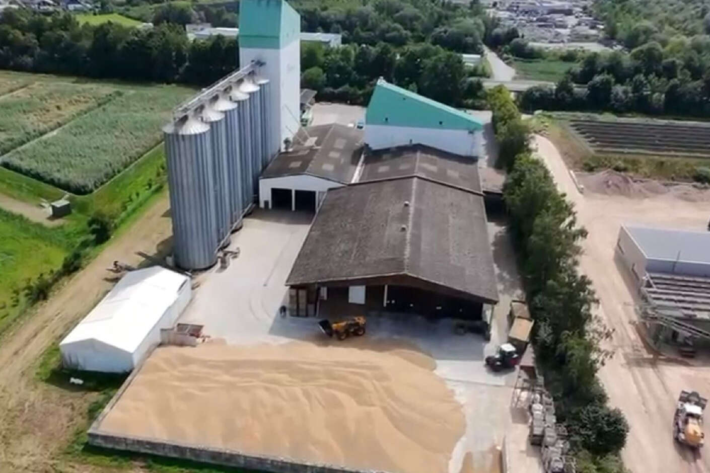 Luftbild eines Getreidelaagers der AGRAVIS Niedersachsen-Süd mit Hallen und Getreide.
