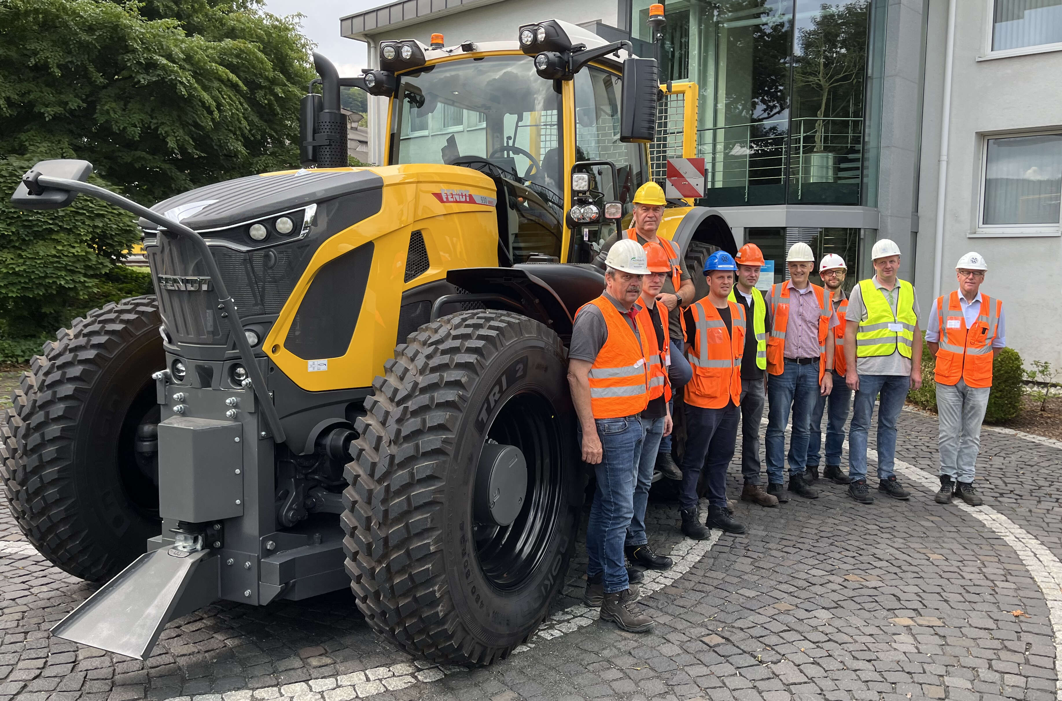 Gruppe mit Schutzwesten vor gelbem Fendt-Traktor