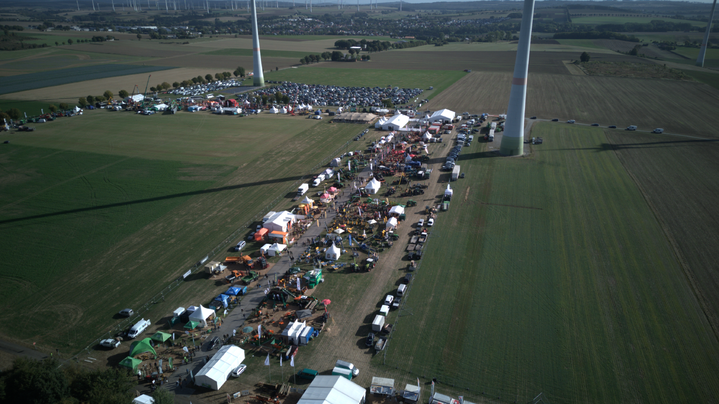 Luftaufnahme einer Landtechnik-Messe mit Ausstellungsständen und Besuchern.