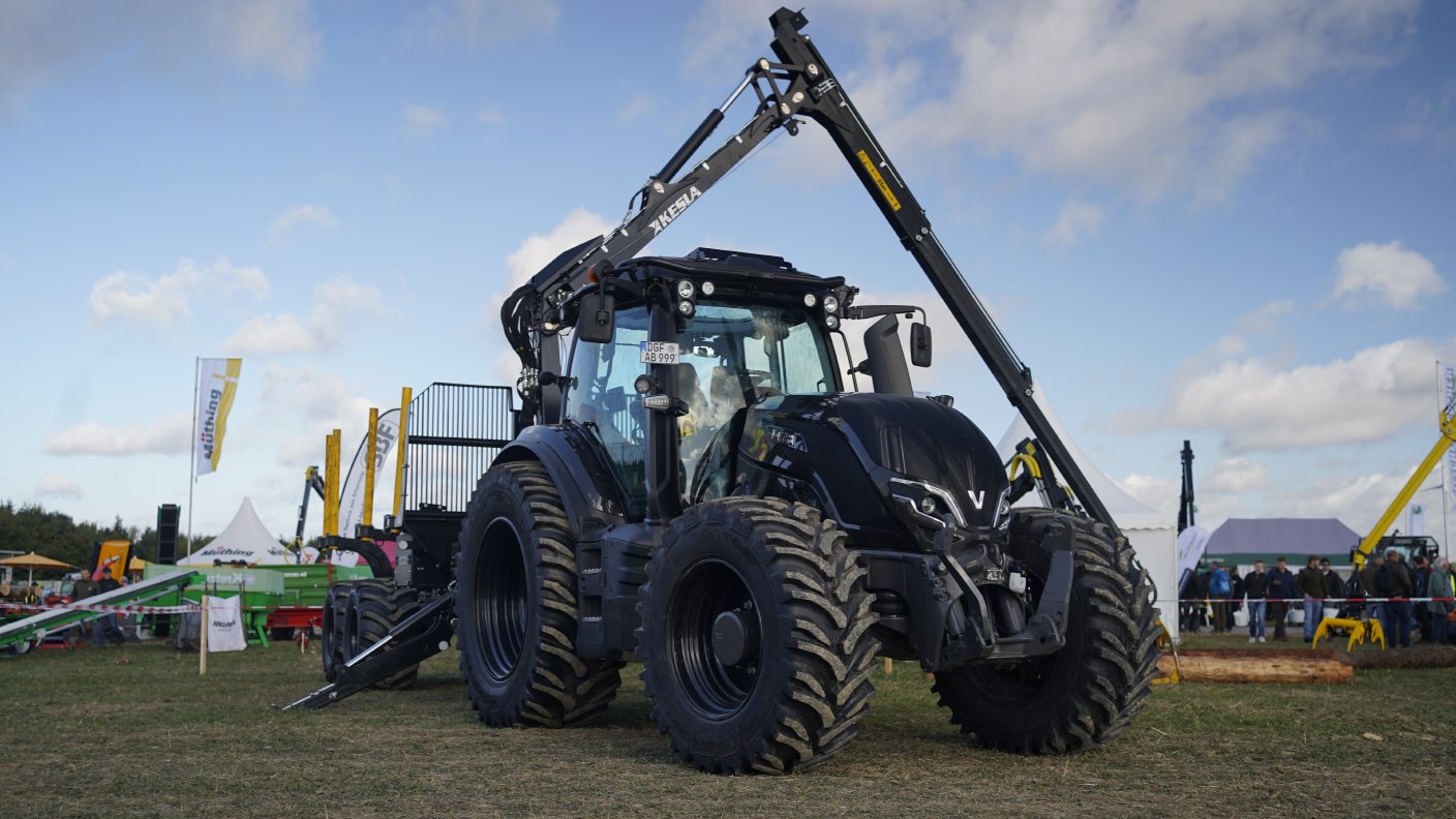 Schwarzer Valtra-Traktor mit Frontlader auf einer Landtechnik-Ausstellung.