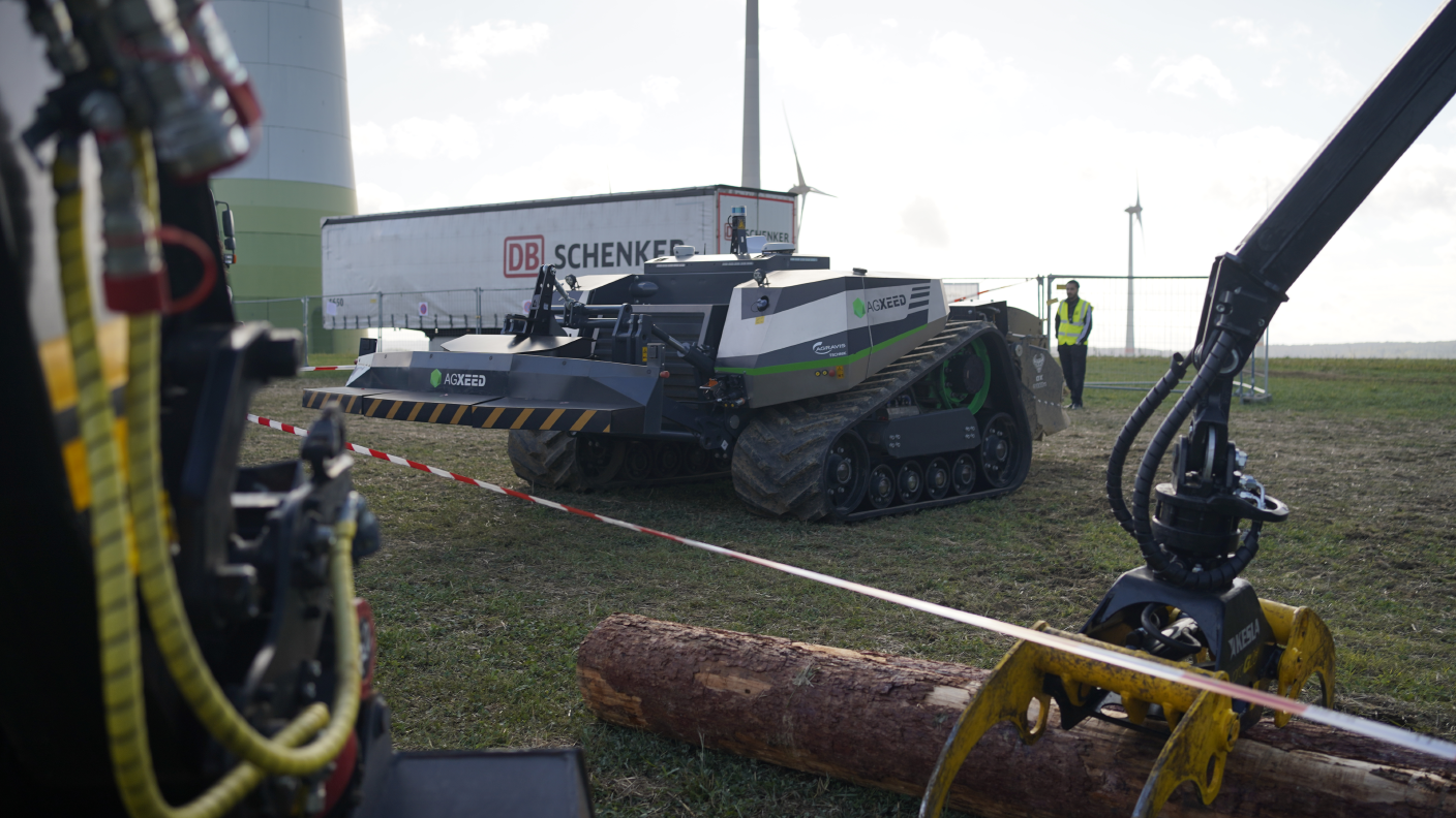 AgXeed-Robotertraktor mit Raupenfahrwerk auf Landtechnik-Demo vor Windrad.