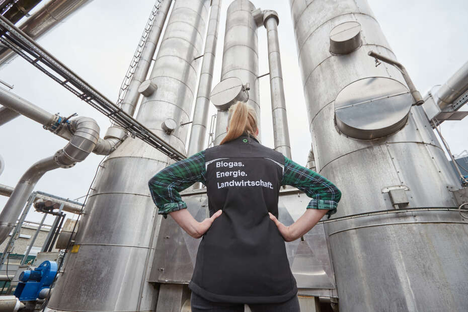 Eine Frau vor einer Biomethanaufbereitungsanlage.