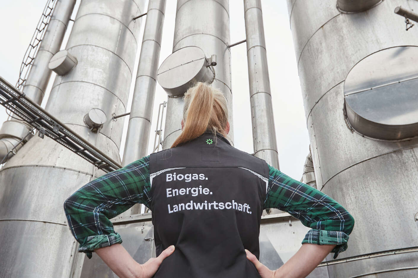 Eine Frau vor einer Biomethanaufbereitungsanlage.