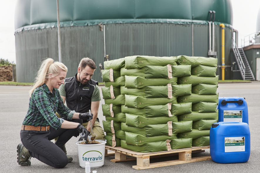 Zwei Personen untersuchen eine Fermenterprobe, im Hintergrund sind Produkte zu sehen.