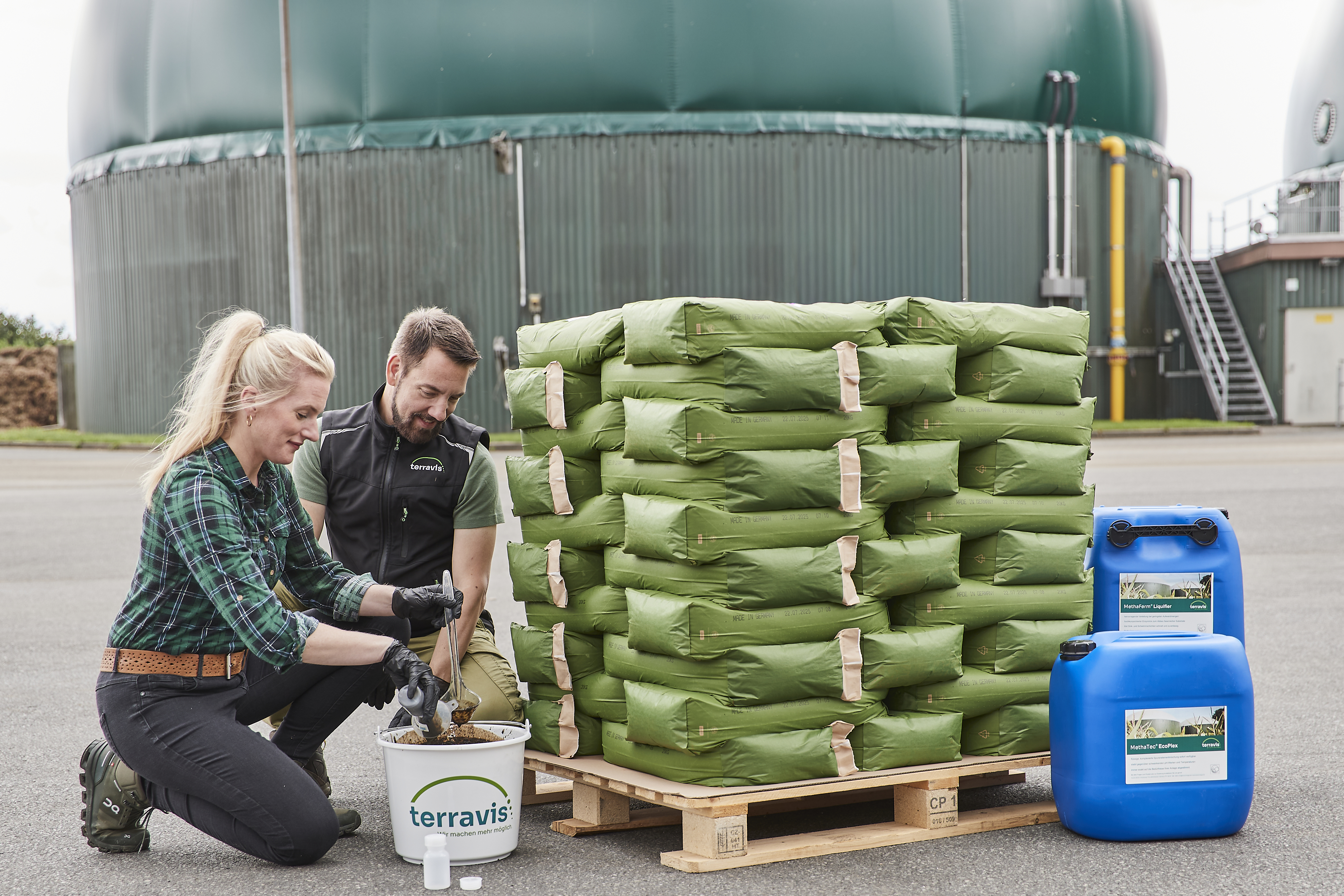 Zwei Personen untersuchen eine Fermenterprobe, im Hintergrund sind Produkte zu sehen.