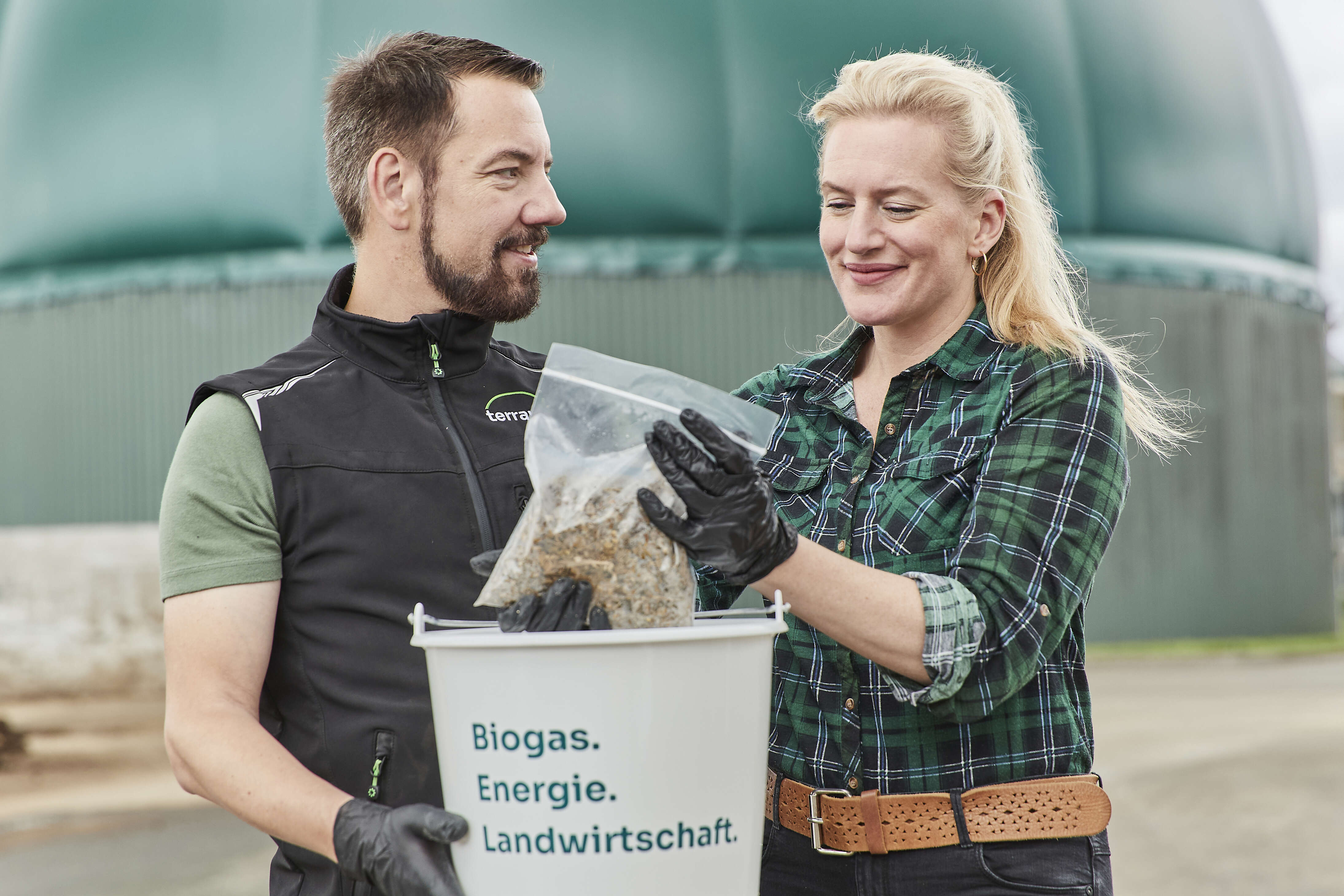 Zwei Personen untersuchen eine Silageprobe.