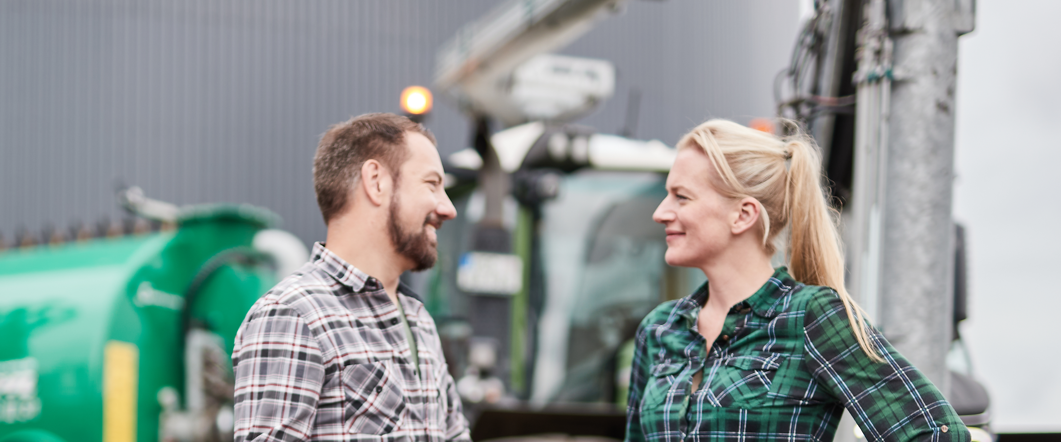 Zwei Personen vor einem Traktor mit Güllefass