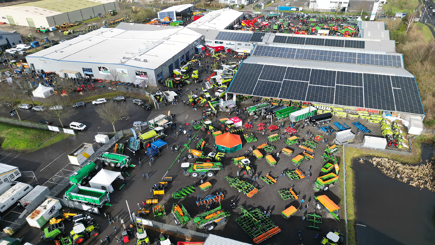 Luftaufnahme einer Landtechnik-Ausstellung mit Traktoren, Anbaugeräten und vielen Besuchern auf eine