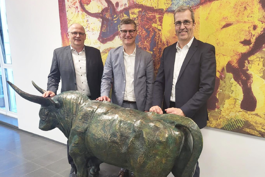 Hermann Hesseler, Tilmann  Fuchs und Dr. Dirk Köckler stehen am AGRAVIS-Stier in der Zentrale. 