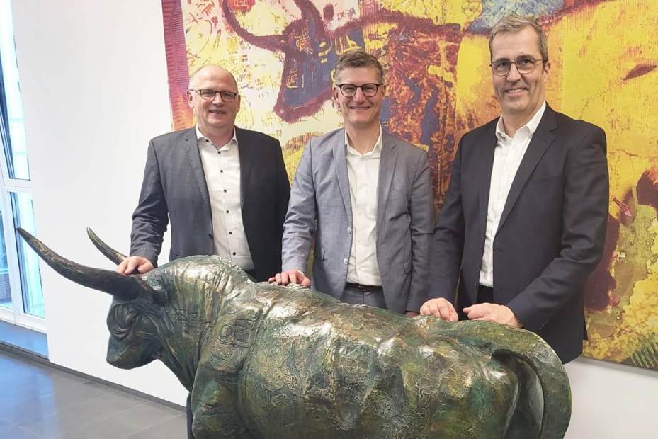 Hermann Hesseler, Tilmann  Fuchs und Dr. Dirk Köckler stehen am AGRAVIS-Stier in der Zentrale. 