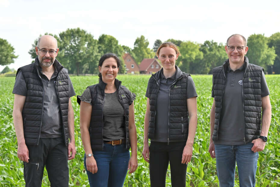 Vier Personen stehen nebeneinander und schauen in die Kamera.