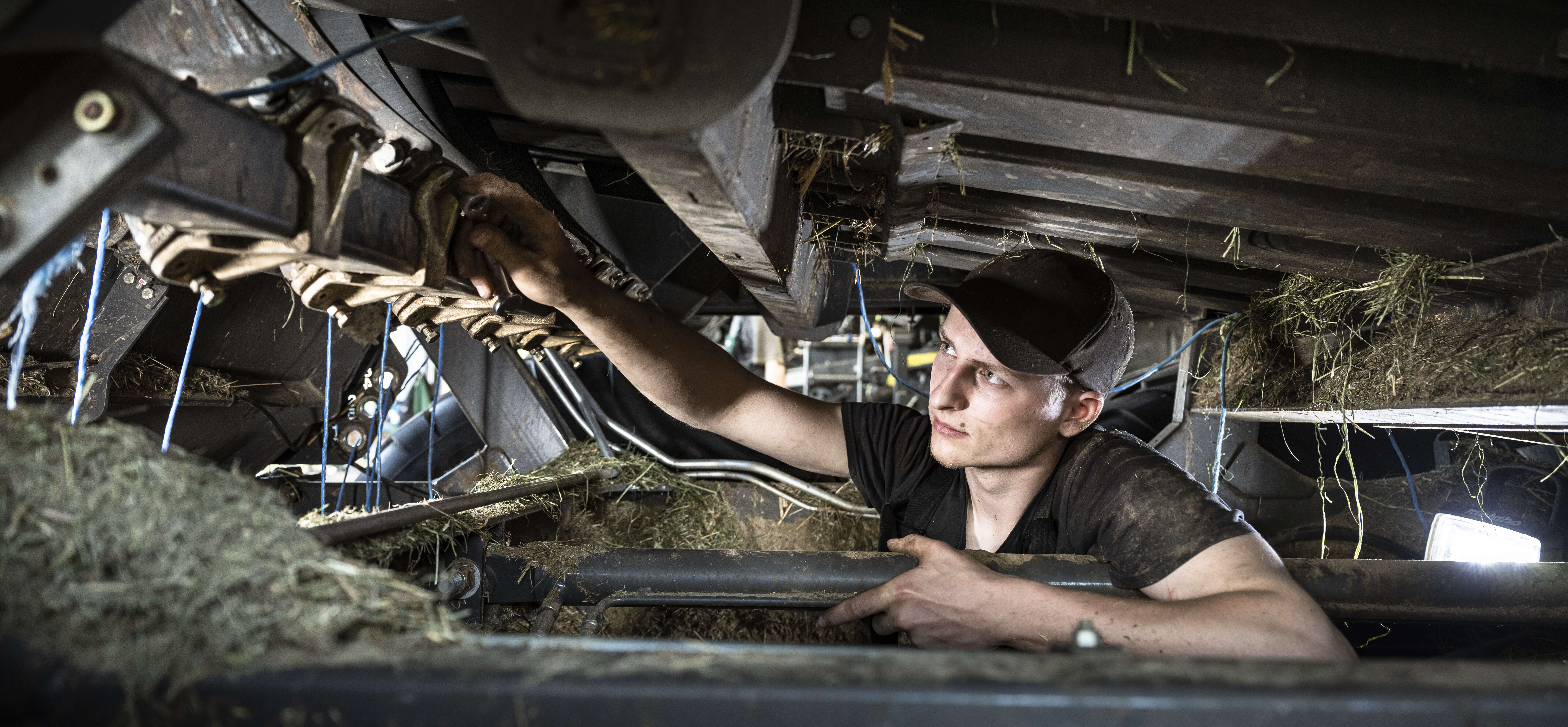 Servicetechniker prüft Bauteile im Inneren einer Erntemaschine.