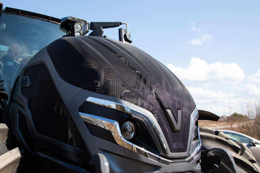 Valtra Traktor Frontansicht mit markanter Motorhaube und Scheinwerfern auf dem Hof abgestellt