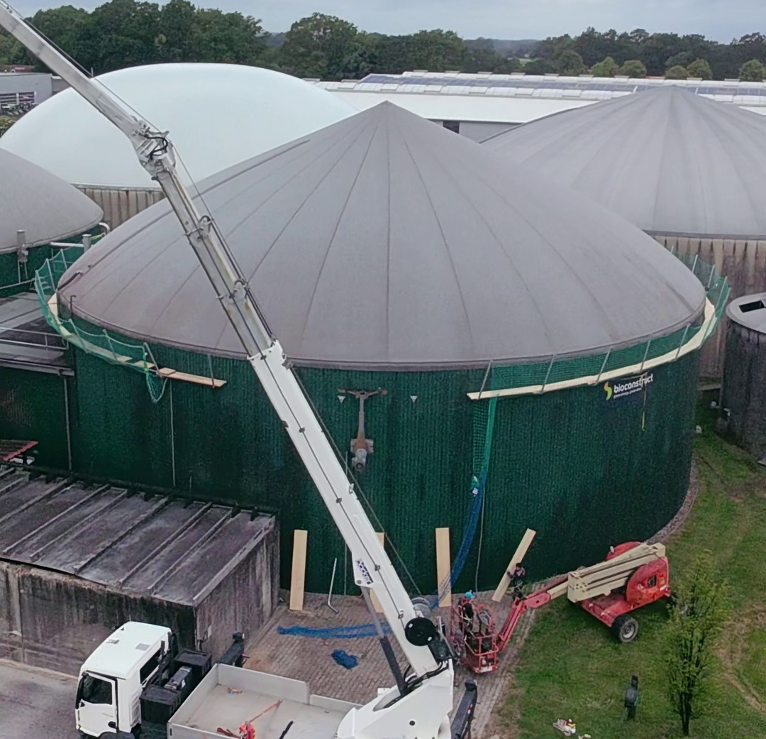 Ein Kran vor einer Biogasanlage. Der Fermenter soll geöffnet werden. 