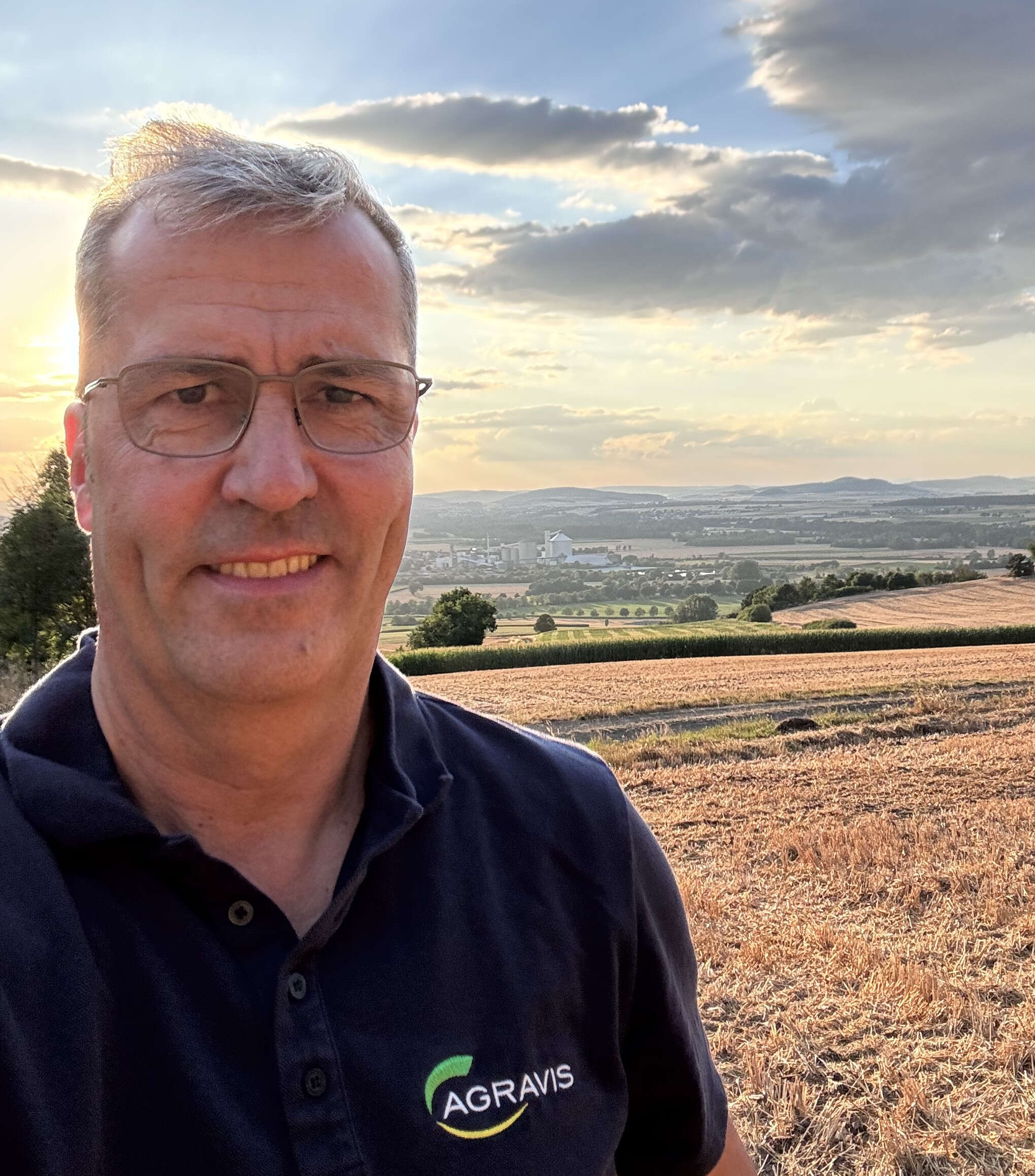 AGRAVIS-CEO Dr. Dirk Köckler steht vor einem gedroschenen Acker.