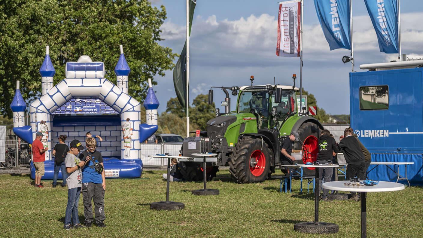 Fendt Traktor vor LEMKEN Fahnen und Hüpfburg auf einer Landtechnikveranstaltung.