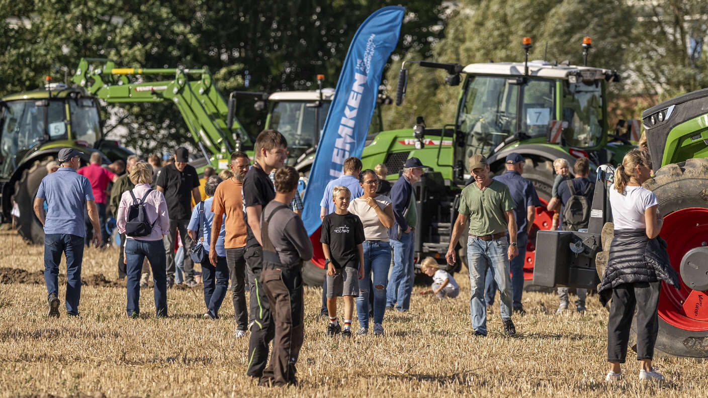Besucher zwischen Fendt Traktoren und Landtechnik auf einem Stoppelfeld.