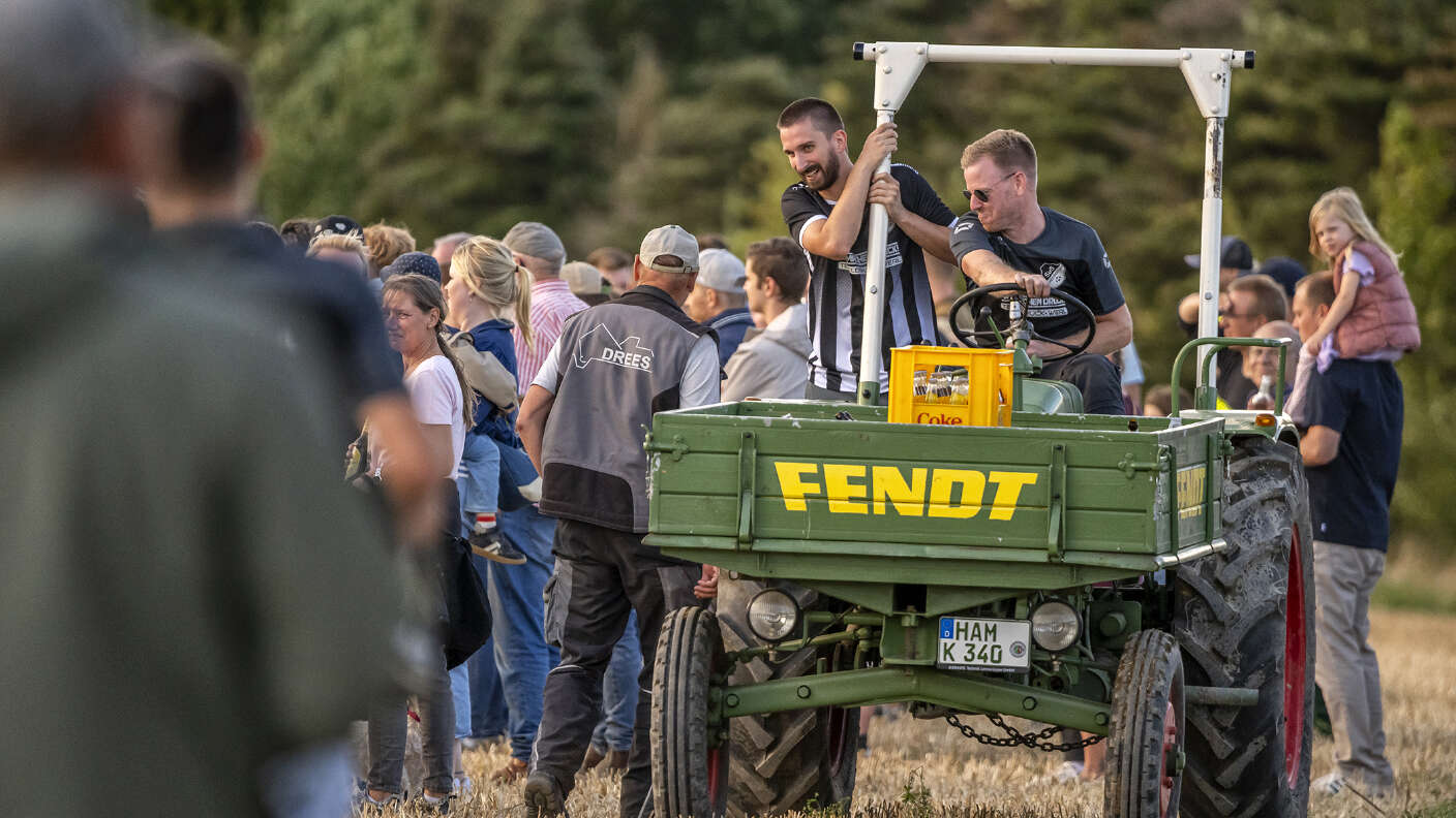 Fendt GT mit Mitfahrern auf einer Landtechnikveranstaltung im Stoppelfeld.