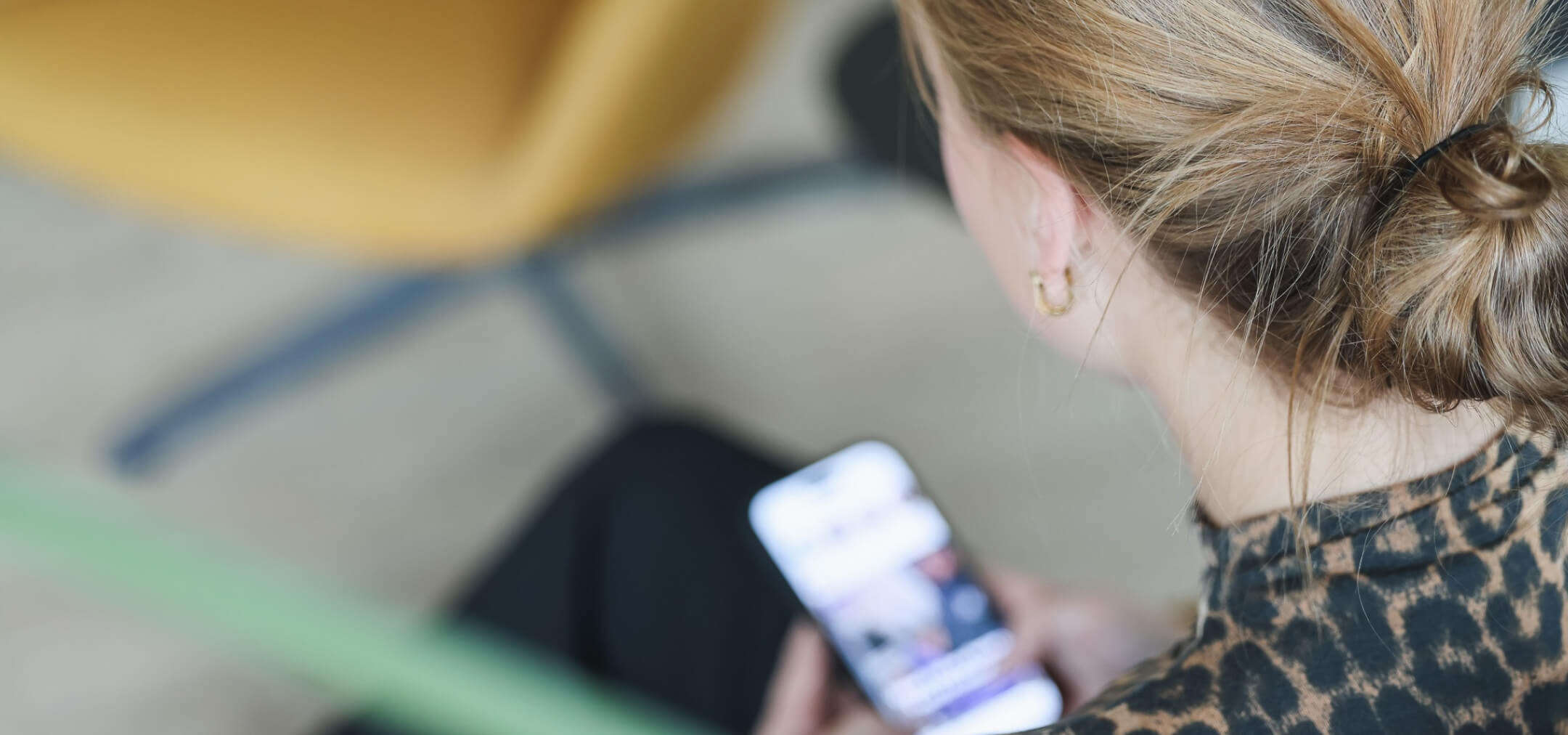 Person mit Handy im Büro